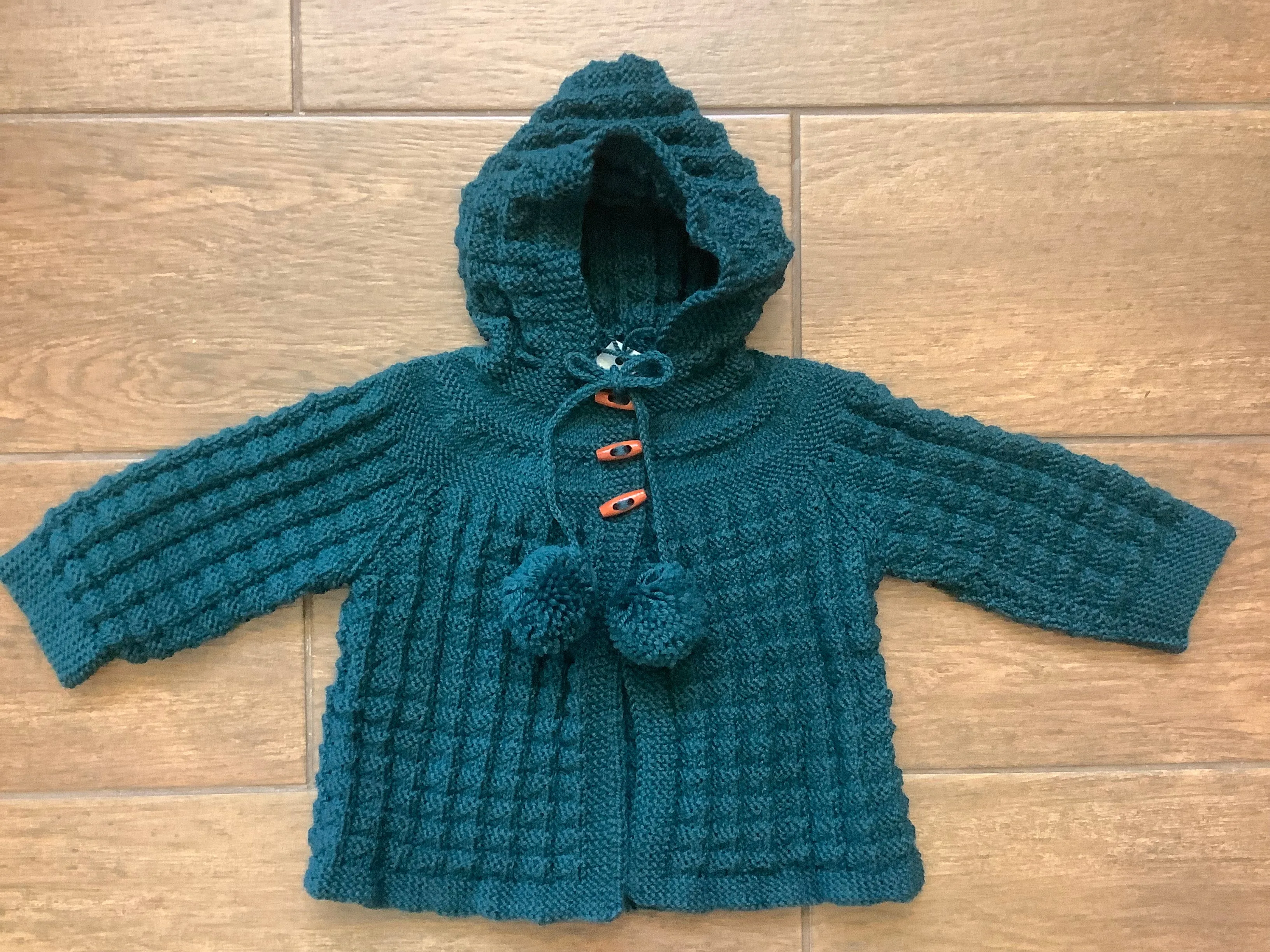 Hand Knitted Hooded Jacket with Pom Poms